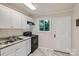 Functional kitchen with white cabinets, black appliances, and granite-look countertops at 3245 Minnesota Rd, Charlotte, NC 28208