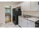 Functional kitchen with white cabinets, black appliances, and granite-look countertops at 3245 Minnesota Rd, Charlotte, NC 28208