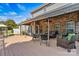 Inviting covered back porch with stone accent wall and comfortable wicker furniture at 7876 Rebecca Rd, Denver, NC 28037