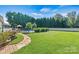 Spacious backyard with in-ground pool, stone walkway, and lush landscaping at 7876 Rebecca Rd, Denver, NC 28037