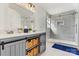 Modern bathroom with double vanity, baskets, sleek shower and neutral color palette at 7876 Rebecca Rd, Denver, NC 28037