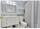 Cozy bathroom features blue walls, white vanity and a classic tiled shower at 7876 Rebecca Rd, Denver, NC 28037