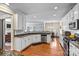 Bright kitchen with stainless steel appliances, granite countertops, and hardwood floors, open to the dining area at 7876 Rebecca Rd, Denver, NC 28037