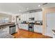 Bright kitchen with stainless steel appliances, granite countertops, white cabinets, and hardwood floors at 7876 Rebecca Rd, Denver, NC 28037