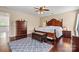 Spacious main bedroom features a dark wood bed frame, a fan, and hardwood floors at 7876 Rebecca Rd, Denver, NC 28037