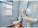 Charming powder room with blue walls, hardwood floors, and stylish fixtures at 7876 Rebecca Rd, Denver, NC 28037