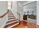 Bright stairway with hardwood floor, light walls, and wooden handrail at 7876 Rebecca Rd, Denver, NC 28037