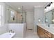 Bright bathroom featuring a modern vanity, freestanding tub, and a glass-enclosed shower with white tile surround at 332 Canvasback Rd, Mooresville, NC 28117