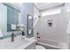 Well-lit bathroom with a bathtub-shower, a niche for storage, white tile surround, and a modern vanity at 332 Canvasback Rd, Mooresville, NC 28117