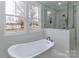 Soaking tub next to a large window and glass-enclosed shower provide a spa-like feel to this bright bathroom at 332 Canvasback Rd, Mooresville, NC 28117