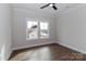 Neutral bedroom featuring wood-look flooring, a ceiling fan, and ample natural light through the double window at 332 Canvasback Rd, Mooresville, NC 28117