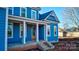 Front view of a two-story blue house with a covered porch and brick steps at 332 Canvasback Rd, Mooresville, NC 28117