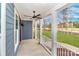 Covered front porch with ceiling fan, offering a pleasant outdoor space to enjoy the lush surroundings at 332 Canvasback Rd, Mooresville, NC 28117