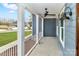 Inviting covered front porch with a ceiling fan, offering a relaxing outdoor space with bright sconce lighting at 332 Canvasback Rd, Mooresville, NC 28117