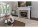 Cozy living room featuring a brick fireplace, modern decor, and sliding glass doors to the outdoor porch at 332 Canvasback Rd, Mooresville, NC 28117