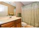 Traditional bathroom with a wood vanity, large mirror, and decorative shower curtain at 102 Cedar Hollow St, Fort Mill, SC 29715