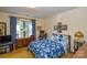 Comfortable bedroom with wood furniture, a cozy floral bedspread, and natural light at 102 Cedar Hollow St, Fort Mill, SC 29715