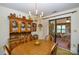 Dining area with a chandelier, wood furniture, and sliding door to additional sunroom at 102 Cedar Hollow St, Fort Mill, SC 29715