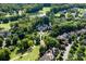 Aerial shot of a grand estate nestled among trees, showcasing a lake and surrounding community at 423 Oakmont Ln, Waxhaw, NC 28173
