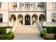 Grand home showcasing a stone staircase, arched doorways, decorative lanterns, and lush landscaping for an elegant curb appeal at 423 Oakmont Ln, Waxhaw, NC 28173