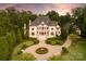 Elegant home showcasing manicured grounds, a circular driveway, and lush landscaping at 423 Oakmont Ln, Waxhaw, NC 28173