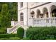 A stately home features manicured greenery, stone staircases, ornate iron lighting, and classic architecture at 423 Oakmont Ln, Waxhaw, NC 28173