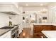 Bright kitchen with custom white cabinetry, central island, and chef's gas range at 423 Oakmont Ln, Waxhaw, NC 28173