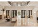 Elegant living room with soaring ceilings, marble floors, access to the patio and pool, plus grand fireplace at 423 Oakmont Ln, Waxhaw, NC 28173