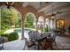Covered patio with stone columns and iron furniture, overlooking a lush yard with pool at 423 Oakmont Ln, Waxhaw, NC 28173