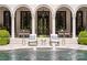 Covered terrace with seating area overlooking a pool with fountains and lush greenery at 423 Oakmont Ln, Waxhaw, NC 28173