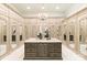 Spacious walk-in closet with custom storage, marble island, and elegant chandelier at 423 Oakmont Ln, Waxhaw, NC 28173