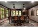 Basement wet bar features dark wood cabinetry, stone floors, and unique lighting fixtures at 423 Oakmont Ln, Waxhaw, NC 28173
