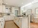 Bright kitchen features white cabinets, granite counters, and an island with cooktop at 1218 Wareham Ct, Charlotte, NC 28207