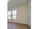 Empty bedroom with hardwood floors, large windows, and white door at 10509 Boudreaux St, Huntersville, NC 28078