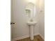 Simple powder room with pedestal sink and circular mirror at 10509 Boudreaux St, Huntersville, NC 28078