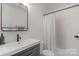 Clean bathroom with white sink, dark vanity, and shower at 11407 Sidney Crest Ave, Charlotte, NC 28213
