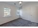 Carpeted bedroom with windows offering views of the outdoors and a white door at 6427 Saint Bernard Way, Charlotte, NC 28269