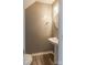Cozy half bathroom featuring a pedestal sink, round mirror, and modern finishes at 6427 Saint Bernard Way, Charlotte, NC 28269