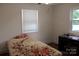 Bright bedroom with a neutral-toned bedspread that has a floral design, and a dark wood desk with a chair at 3329 Draper Ave, Charlotte, NC 28205