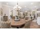 Open dining room with a round table, kitchen view, and stylish chandelier at 859 Irish Creek Dr, Landis, NC 28088