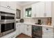 Well-equipped kitchen features double ovens, beverage fridge, and white shaker cabinets at 859 Irish Creek Dr, Landis, NC 28088