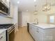 Modern kitchen with white cabinets, quartz countertops, and island at 10513 Boudreaux St, Huntersville, NC 28078