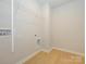 Bright laundry room with built-in shelving and vinyl flooring at 10513 Boudreaux St, Huntersville, NC 28078