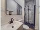 Modern bathroom with walk-in shower, gray tile, and black accents at 818 N Jackson St, Salisbury, NC 28144