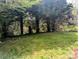 A view of the home's backyard featuring a lush lawn and mature trees in the background at 1327 Phil Oneil Dr, Charlotte, NC 28215
