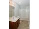 Bright bathroom featuring a shower-tub combo, a wood vanity, and neutral tile flooring at 1327 Phil Oneil Dr, Charlotte, NC 28215