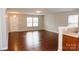 Bright living room with hardwood floors and neutral paint, showcasing an open floor plan with the kitchen in the background at 1327 Phil Oneil Dr, Charlotte, NC 28215