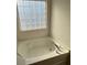A relaxing bathtub below a window with an obscured glass pane to allow in natural light at 2548 Sweet Birch Ct, Gastonia, NC 28054