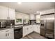 Modern kitchen with white cabinets, stainless steel appliances, and black countertops at 60 Hunter Bridge Rd, Stony Point, NC 28678