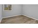 Bedroom with neutral walls, wood-look floors, and window with blinds at 140 Lake Concord Ne Rd # D9, Concord, NC 28025